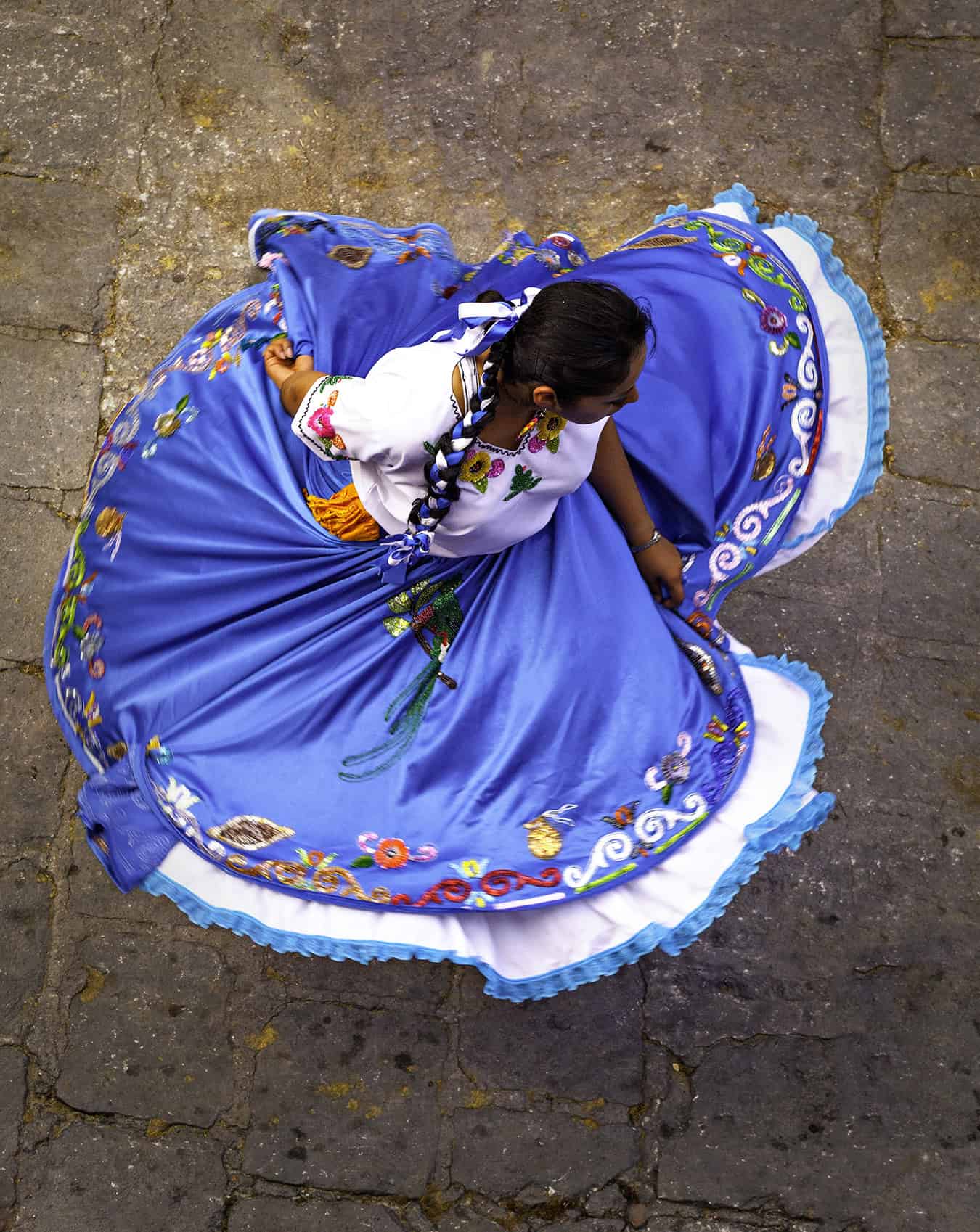 Vibrant traditional Mexican dress worn by a dancer in San Miguel, featuring colorful embroidery and full skirt.