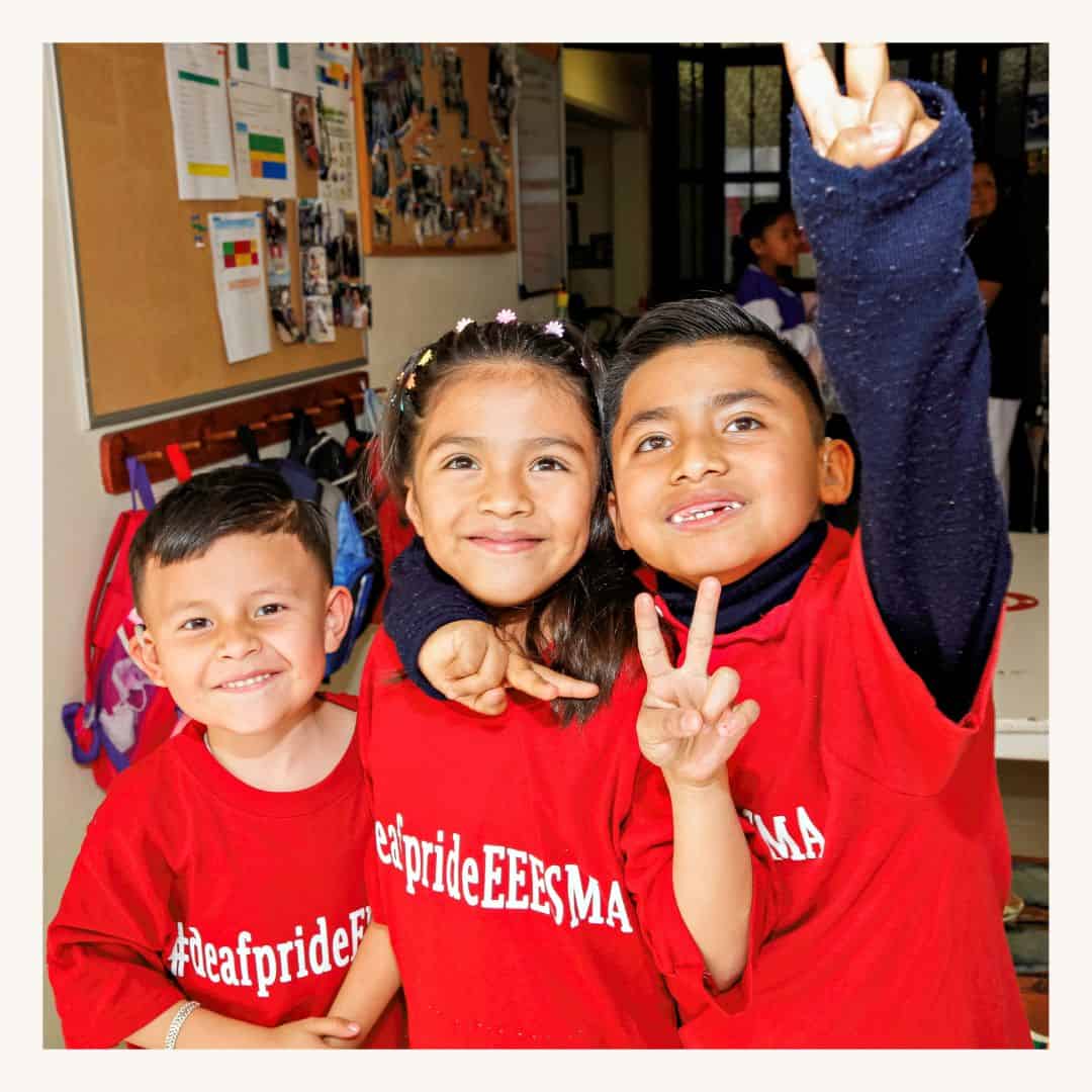 Happy children wearing, smiling and making peace signs indoors, featuring the impact of a San Miguel Community Foundation Nonprofit Network Member organization.